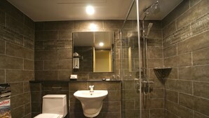 Un baño moderno con inodoro, lavamanos y ducha.