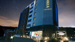 Un hotel de varios pisos con un cartel llamativo que dice "BENIKEA I-JIN HOTEL".
