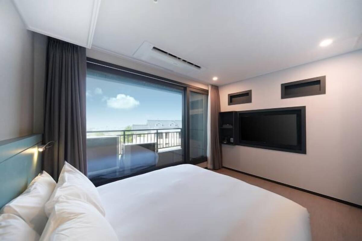 1 dormitorio, ropa de cama de alta calidad, escritorio y cortinas opacas