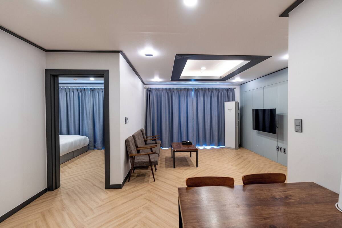 A modern hotel room with a bed, a desk, and a TV.