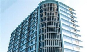 A tall, curved hotel building with a modern design, featuring multiple balconies and a glass facade. - Shwe Phyu Hotel (Mandalay)