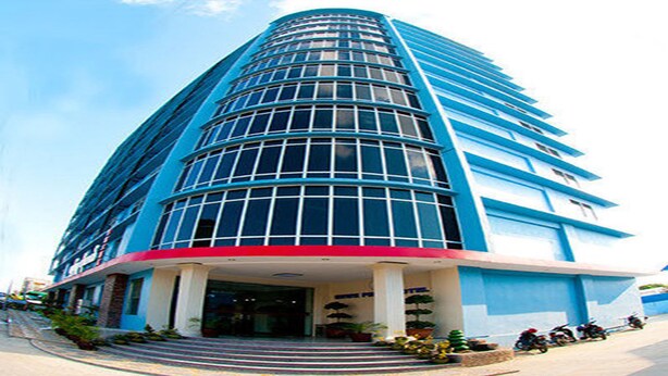 Un hotel moderno con fachada curva, ventanas amplias y entrada en rojo y azul.