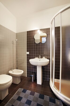 A bathroom with a toilet, bidet, sink, and shower. - Residenza Il Fiore (Bergamo)