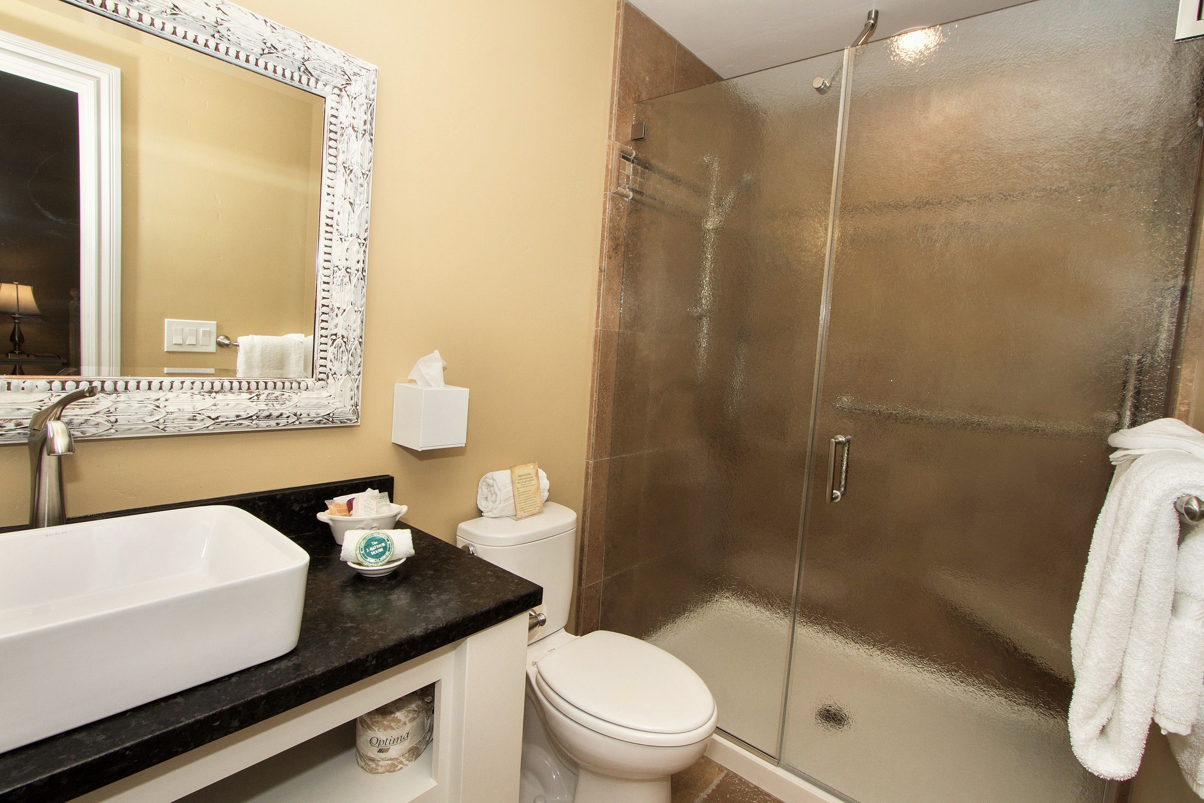 A bathroom with a white sink, a toilet, and a glass-enclosed shower.