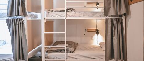 Habitación con literas, escritorio y lámpara.