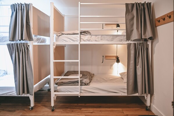 Habitación con literas, escritorio y lámpara.
