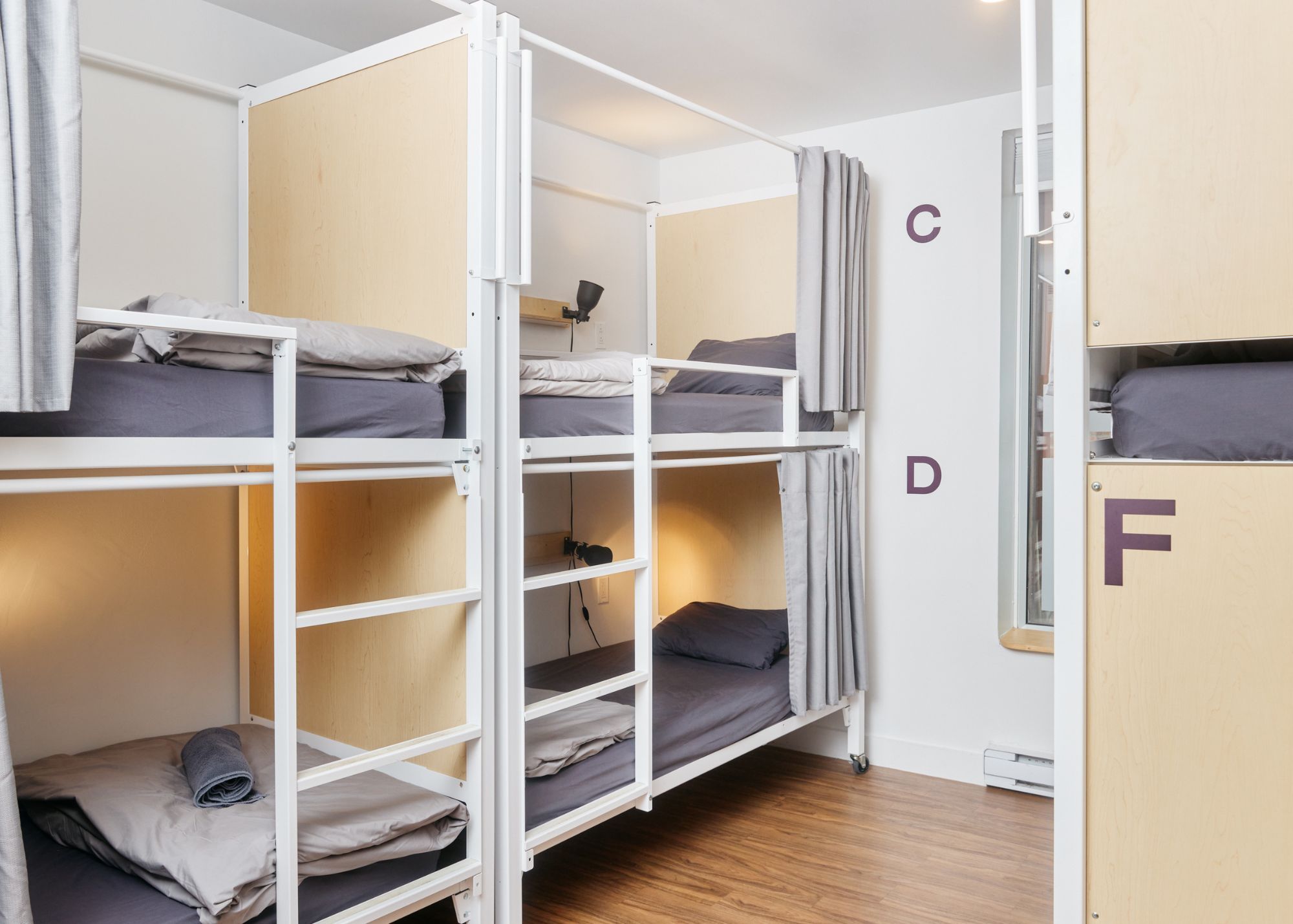 A bunk bed room with a desk and a window.