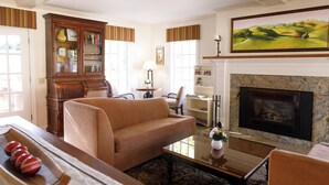 A living room with a fireplace, a sofa, a coffee table, and a bookshelf.