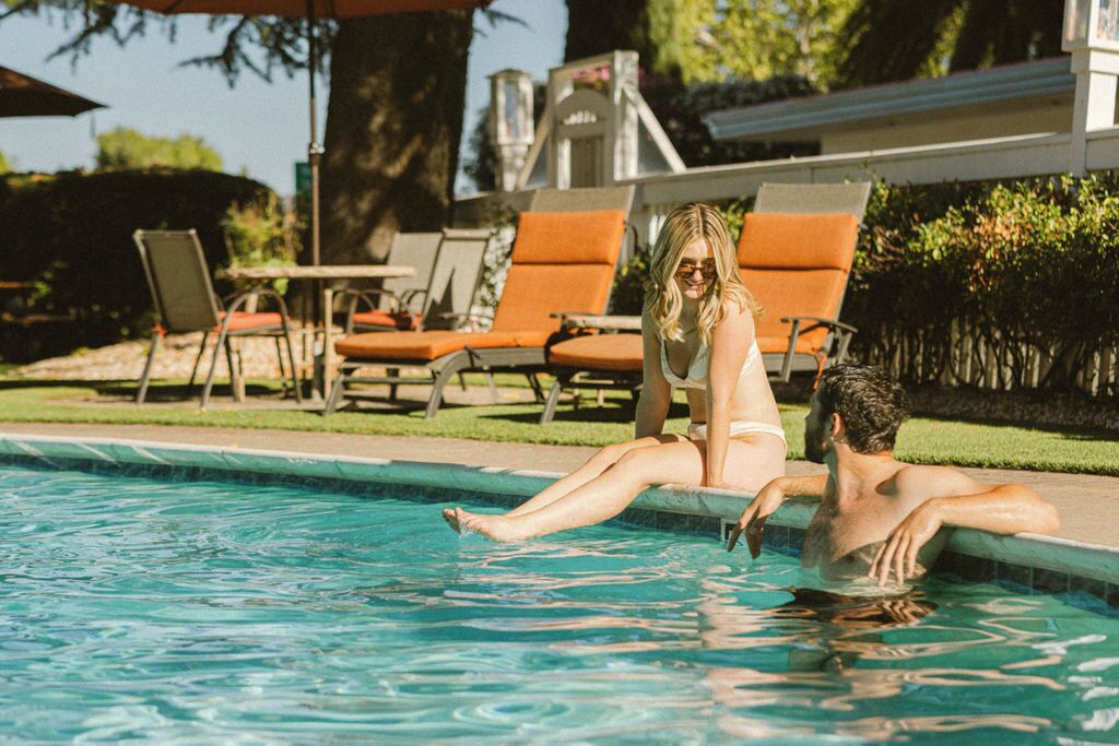 Una piscina con sillones de descanso y sombrillas.