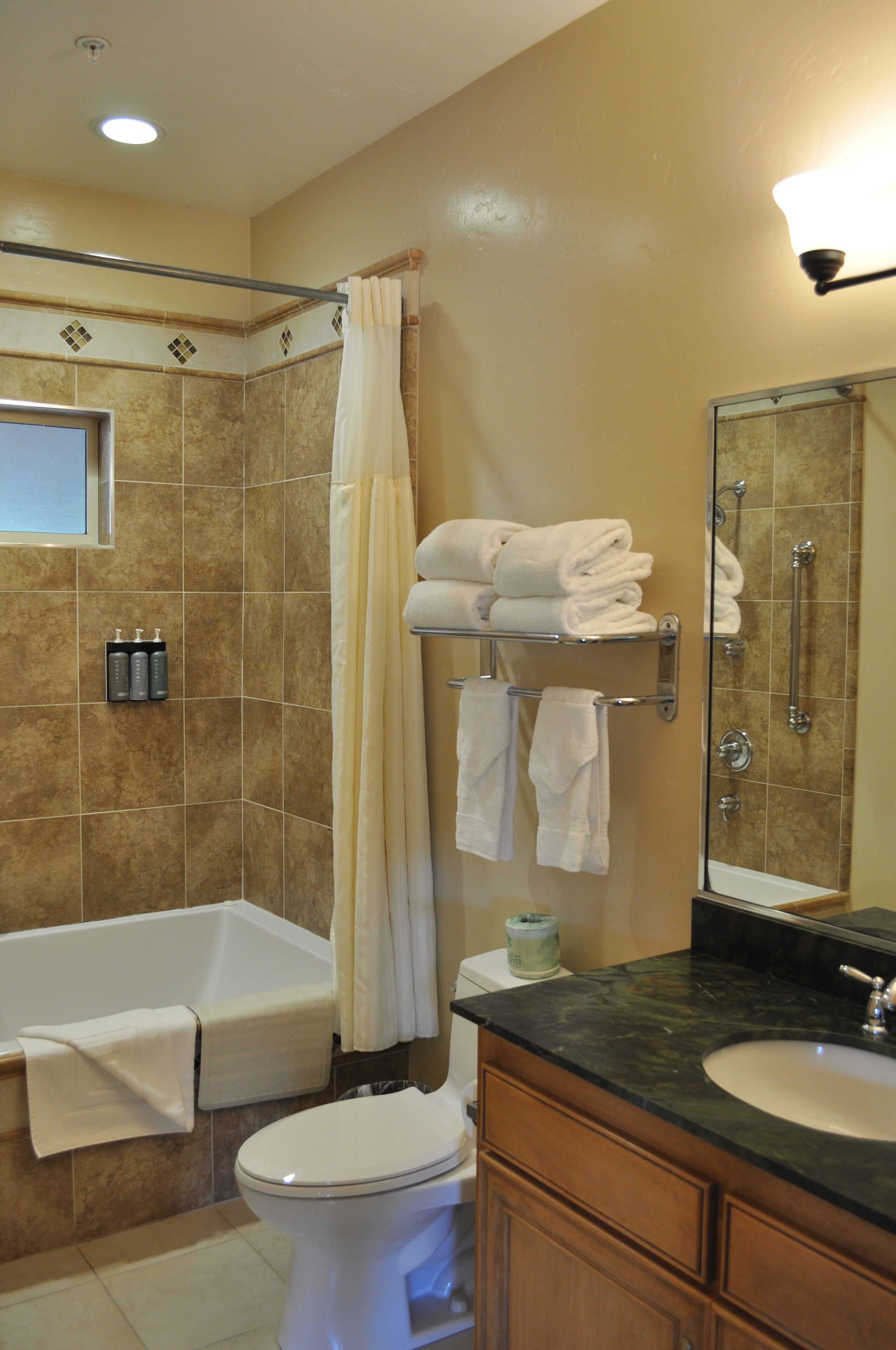 A bathroom with a bathtub, toilet, sink, and a shower area.