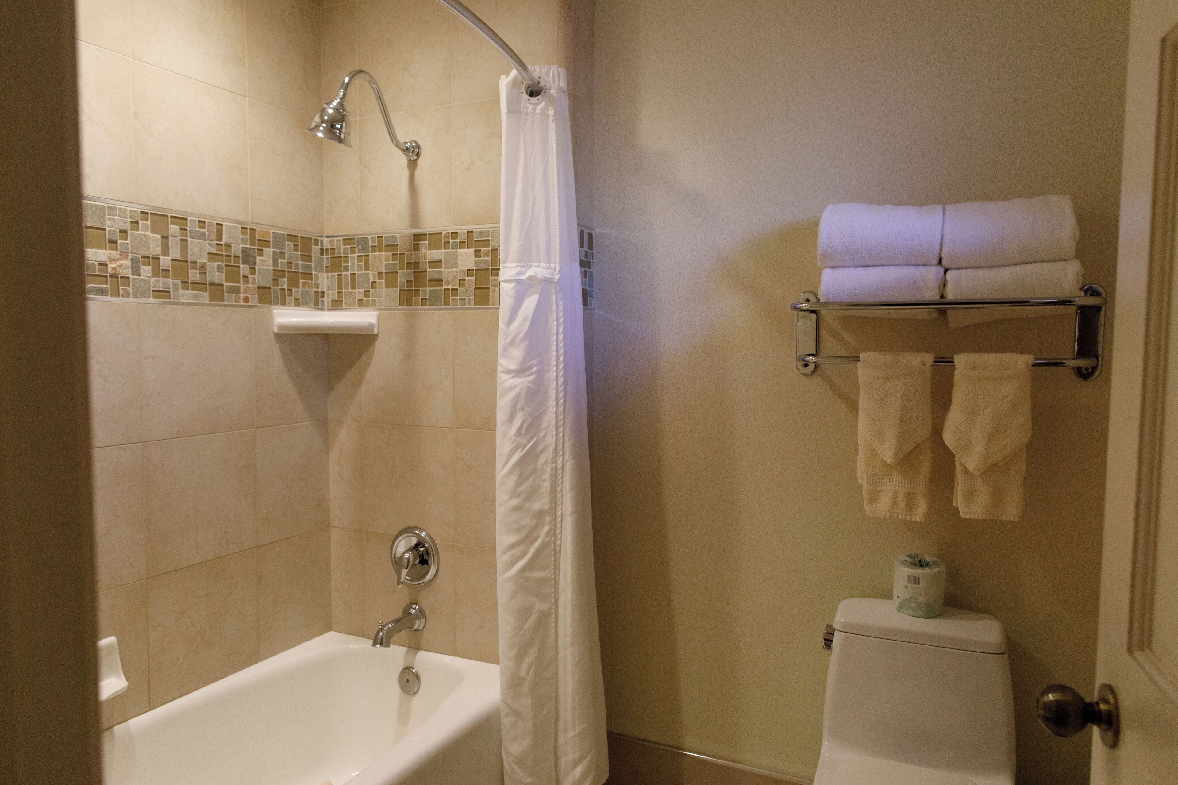 Une salle de bain avec une baignoire, un rideau de douche et un porte-serviettes avec des serviettes.