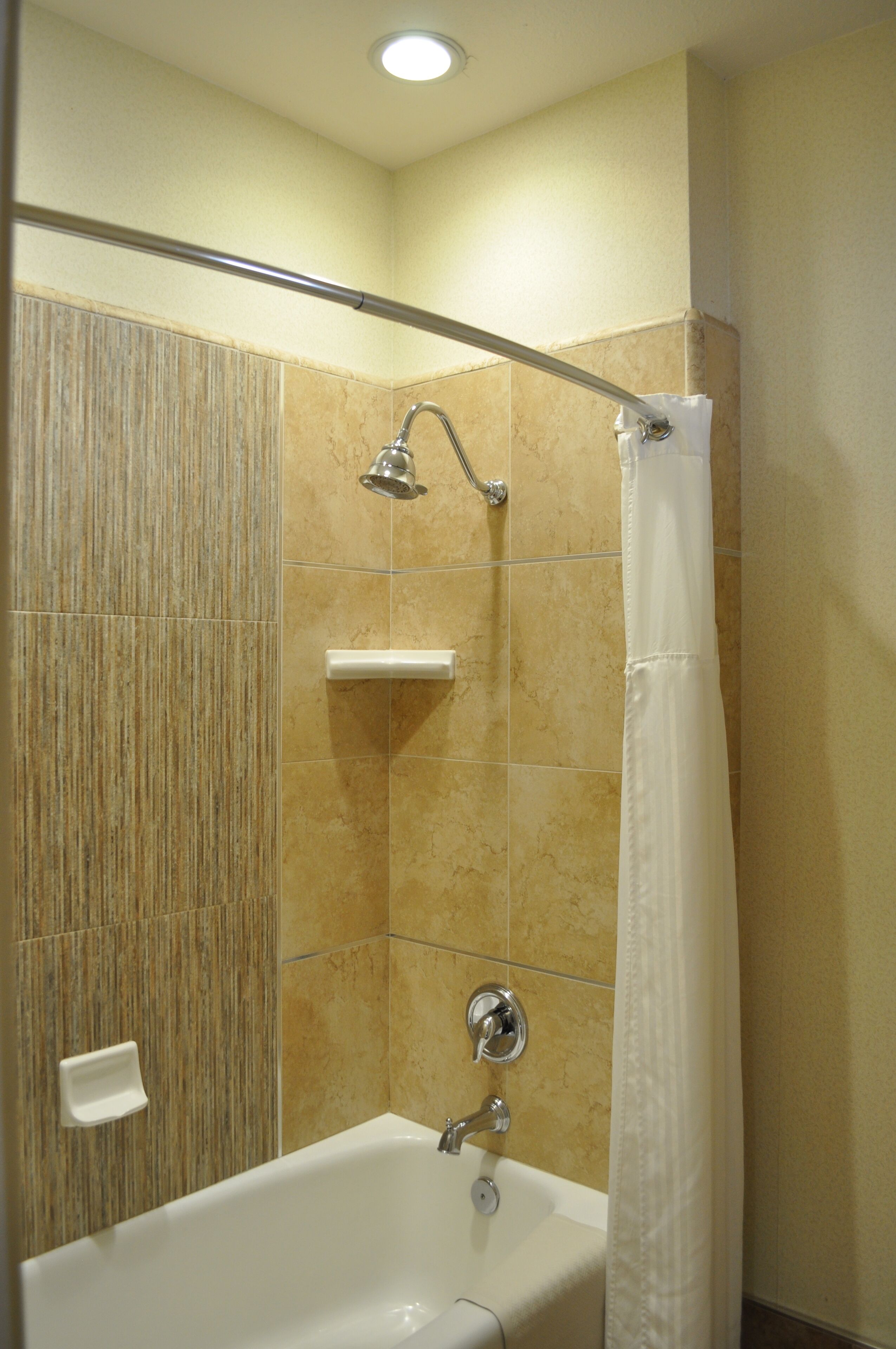 A bathroom with a bathtub, shower, and a towel rack.