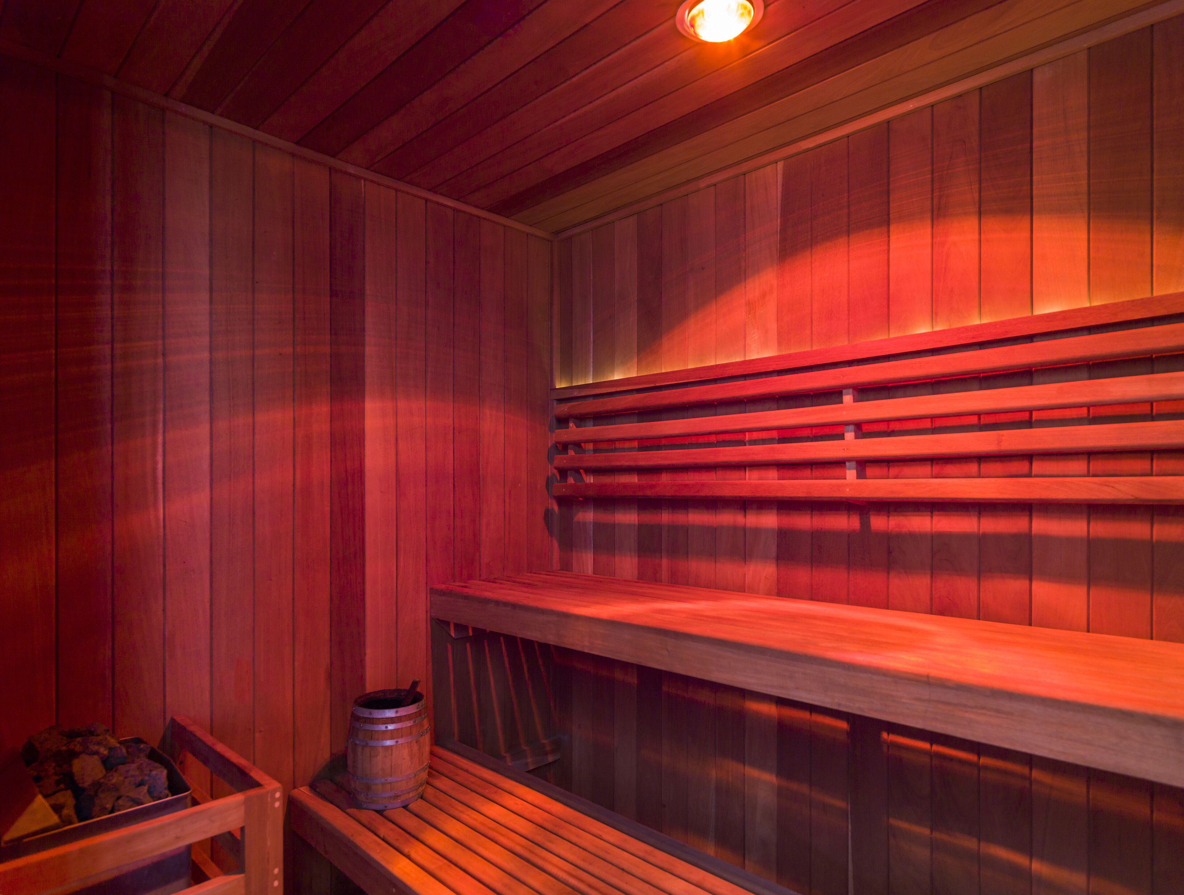 A sauna with wooden benches and a wooden barrel.