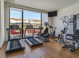 A gym with treadmills, elliptical machines, and weight equipment.