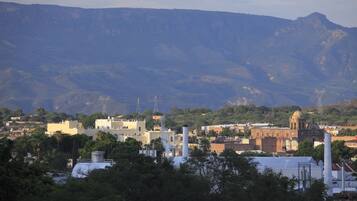 A town with industrial buildings, a church, and mountains in the background.