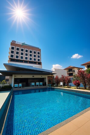 Un hotel con piscina, cielo iluminado y vistas claras de la arquitectura del edificio.