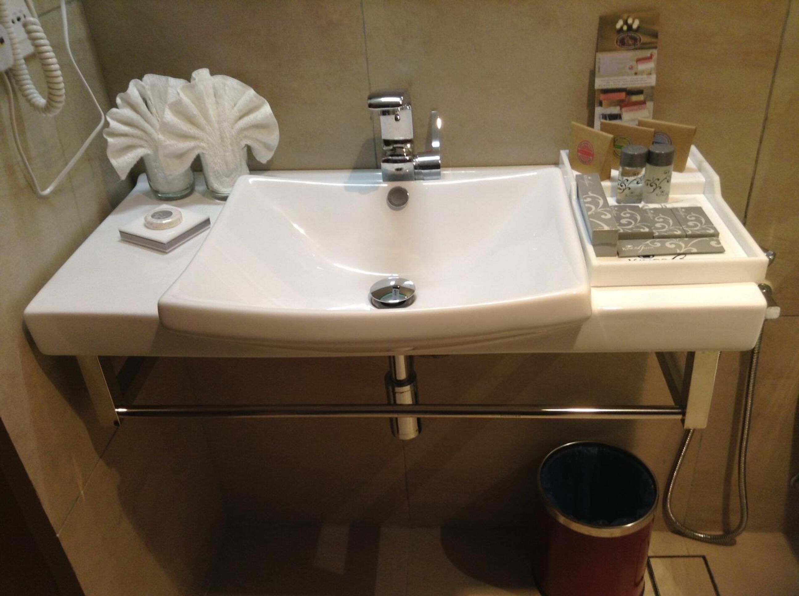 Een badkamermeubel met een wastafel, een zakdoekdispenser en toiletartikelen.