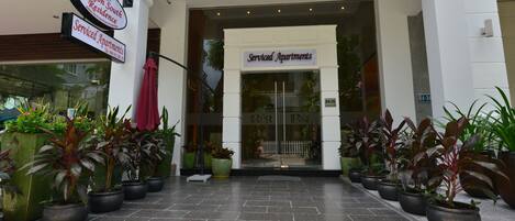 Entrada de um prédio com placa indicando "Serviced Apartments" e placa "Saigon South Residence".