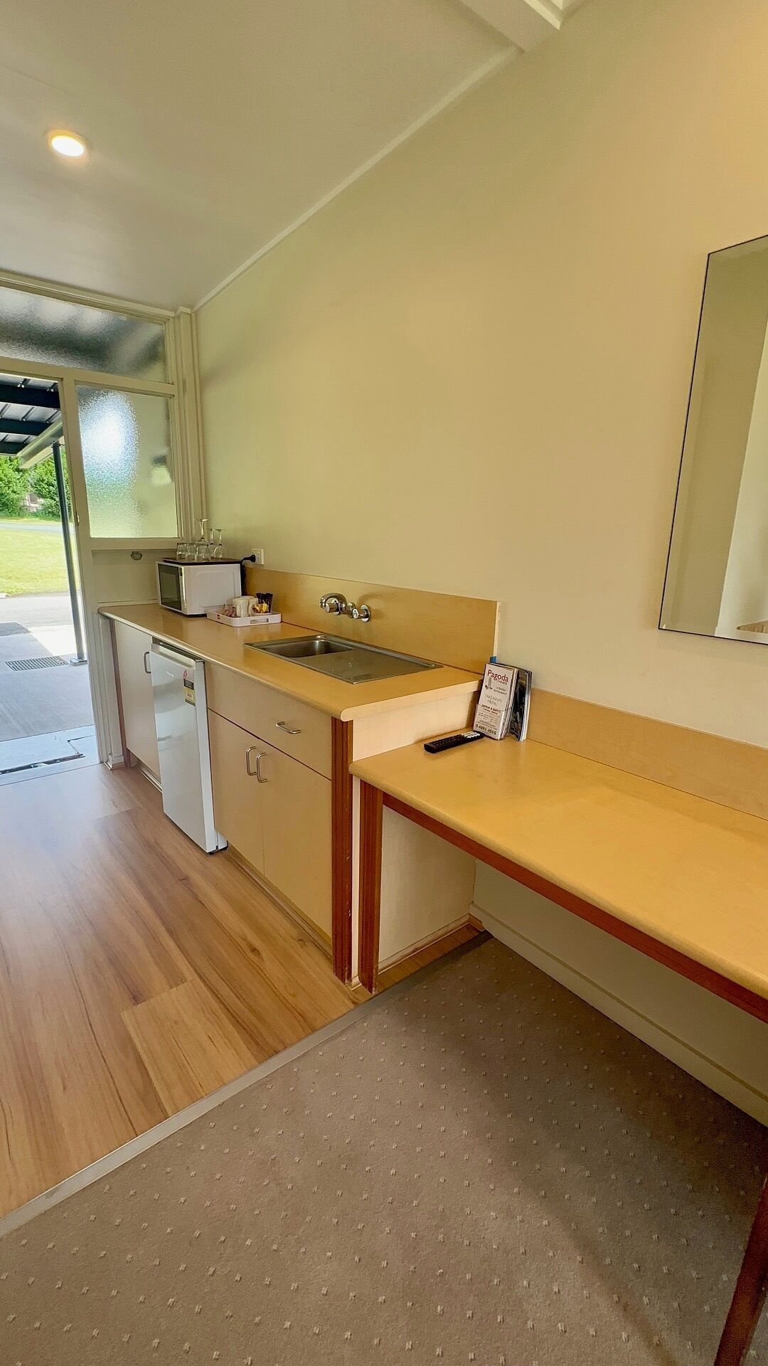 A compact kitchen with a microwave, sink, and refrigerator.