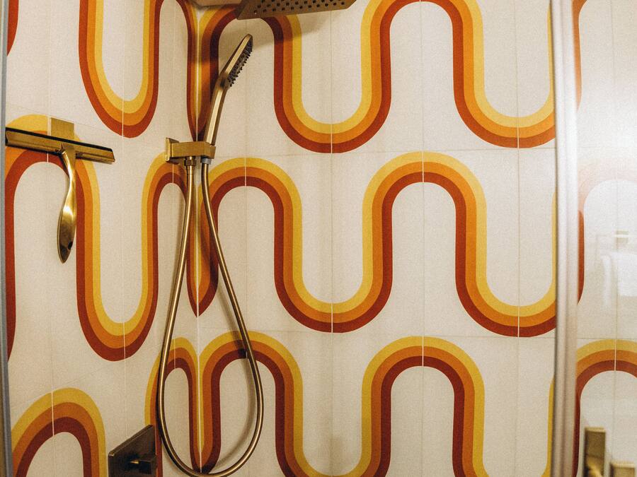A shower with a modern design, a handheld showerhead, and a handheld shower nozzle.