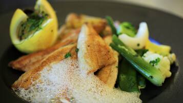 Ein Teller mit Fisch, Zitrone und Gemüse.