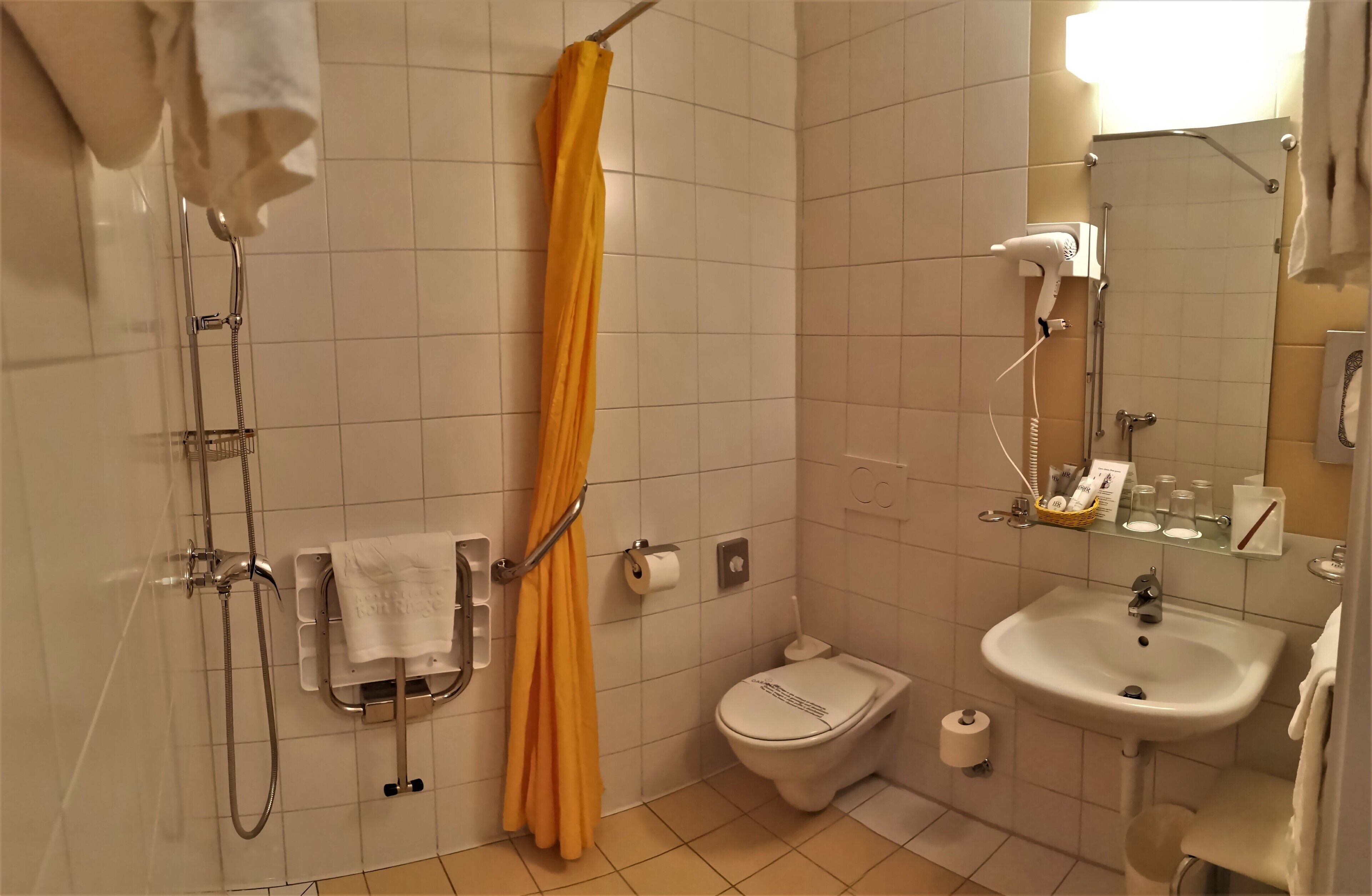 Ein Badezimmer mit Dusche, Toilette, Waschbecken und Handtuchhalter.