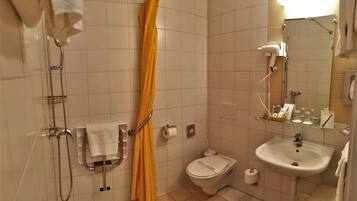 Ein Badezimmer mit Dusche, Toilette, Waschbecken und Handtuchhalter.