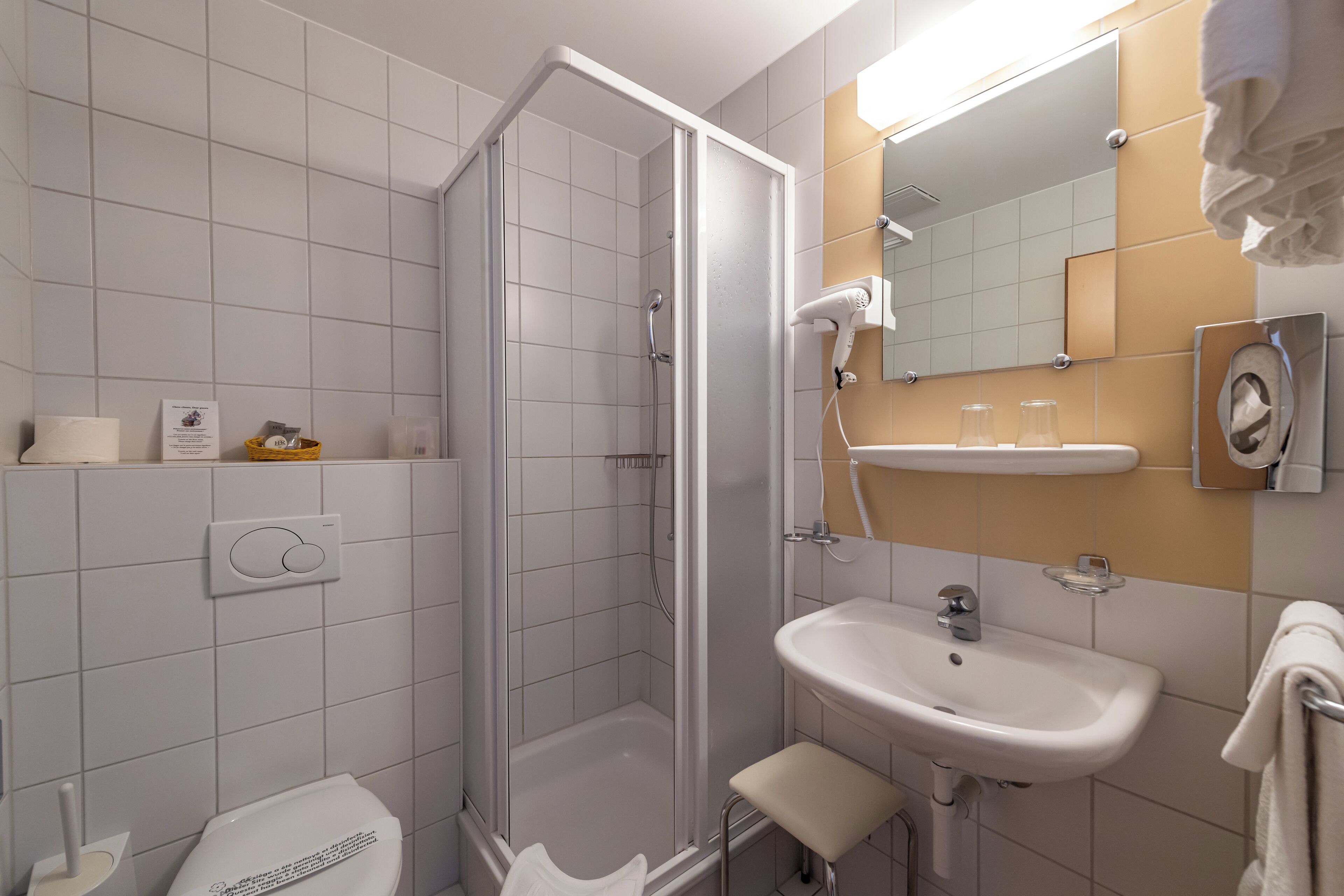 Un baño moderno con ducha, lavamanos e inodoro.