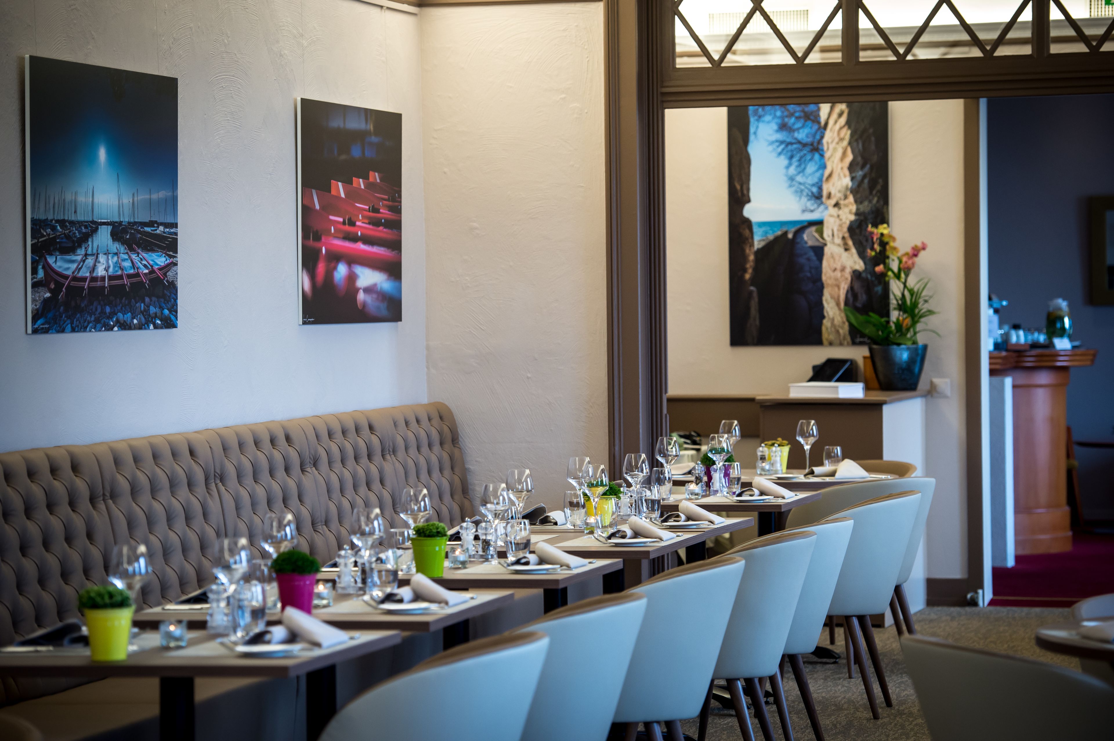 Un comedor con una larga mesa dispuesta para una comida, un banco acolchado y obras de arte en las paredes.