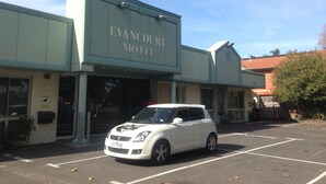 The exterior of the Evangcourt Motel with a white car parked in front. - Evancourt Motel (Malvern East)