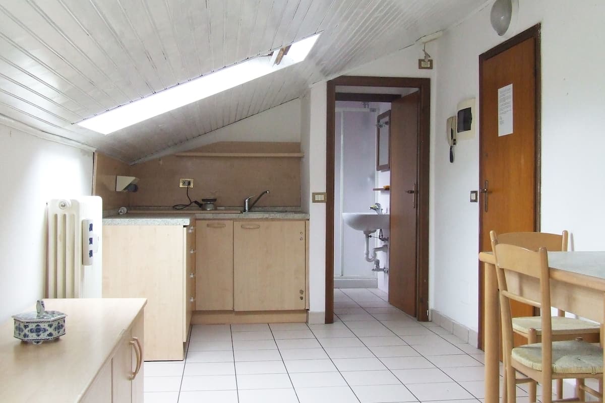A kitchen with a skylight, a sink, and a dining area with chairs.