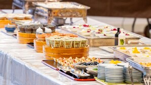 A buffet table with various food items and serving utensils. - Sansuien (Kochi)
