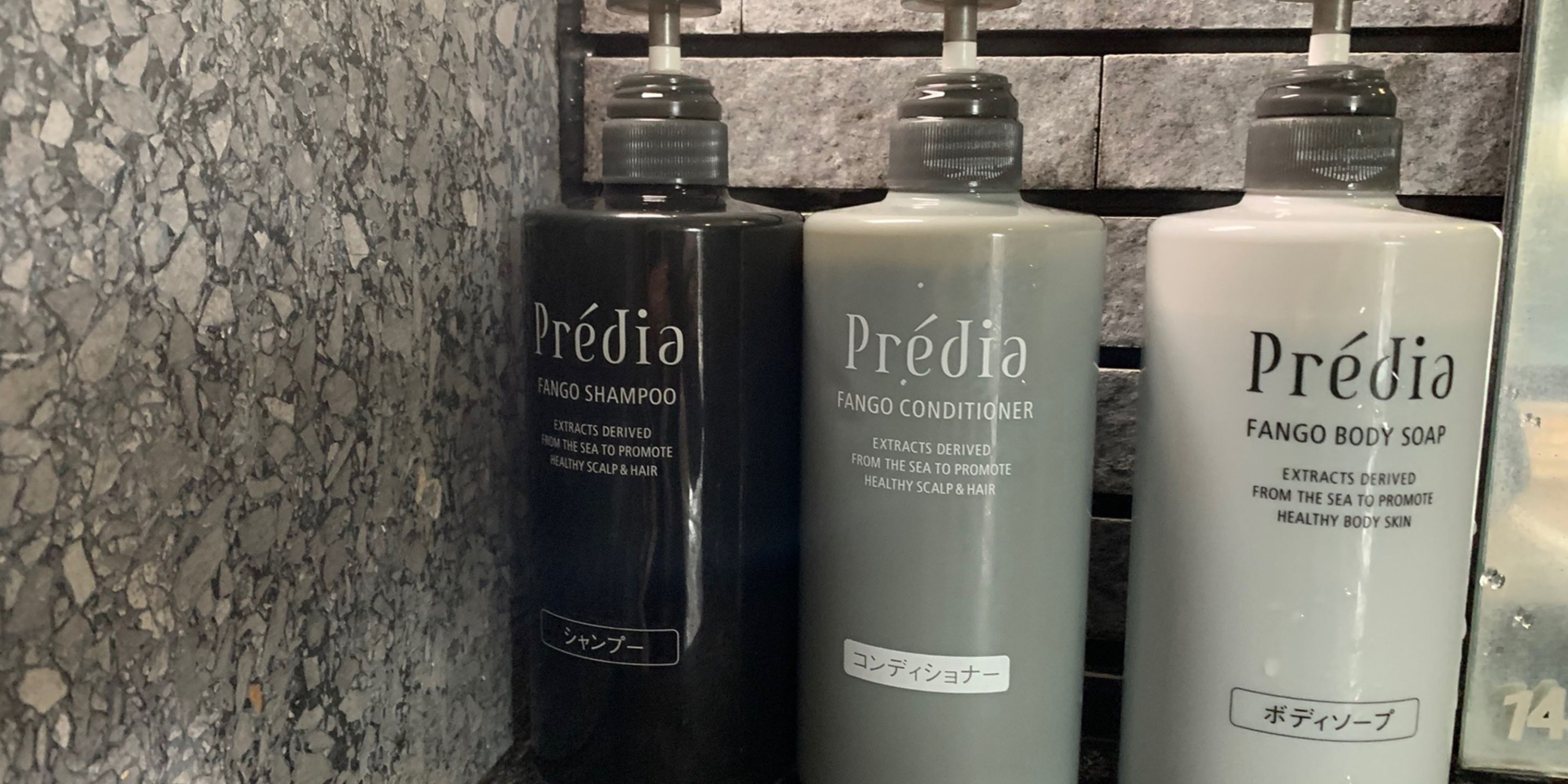 Three bottles of Prédia hair care products on a shelf.