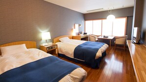 A hotel room with two beds, a desk, a chair, a lamp, and a large window. - Sansuien (Kochi)