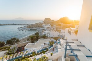 A coastal town with white buildings, a beach, and boats. - Arhontiko Hotel (Karpathos)