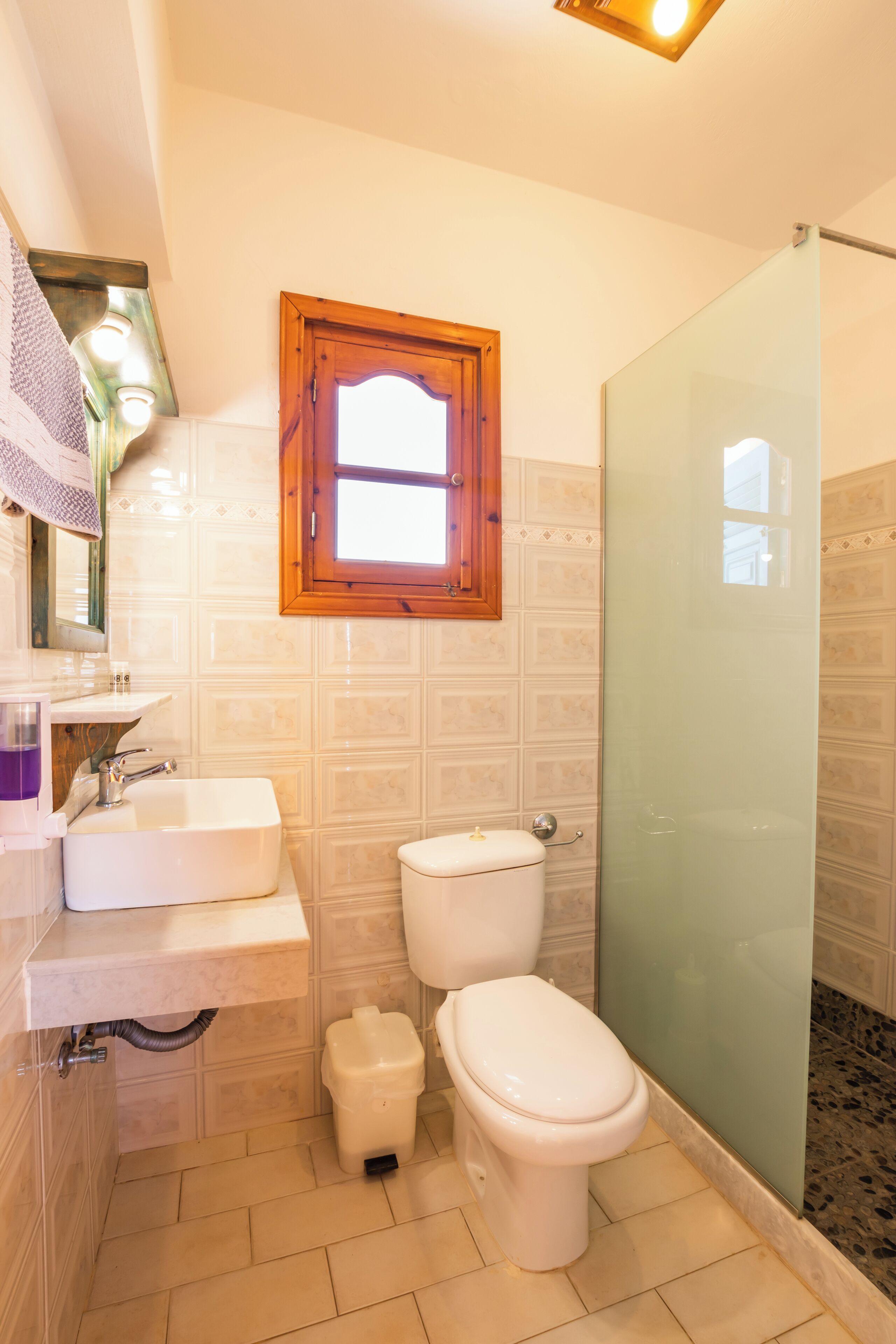 A bathroom with a white sink, toilet, and shower.