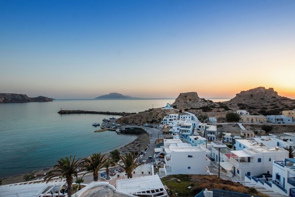 A coastal town with white buildings, a beach, and boats. - Arhontiko Hotel (Karpathos)