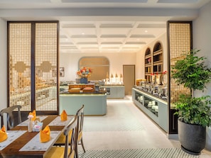 A modern hotel lobby with a reception desk, seating area, and decorative elements.