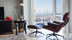 A modern office chair with a high backrest and wheels, positioned near a window with a view of a marina. - 512 The Granger (Cape Town)