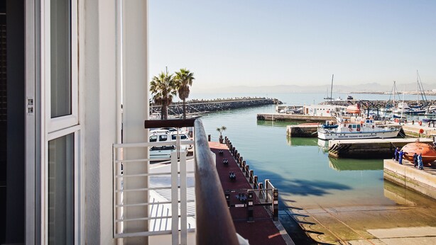 A marina with boats docked, a clear sky, and a palm tree. - 512 The Granger (Cape Town)