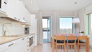 A modern kitchen with white cabinetry, a built-in oven, and a Siemens dishwasher. - Forenom Serviced Apartments Tampere Pyynikki (Tampere)