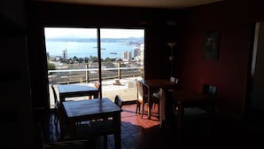 Une chambre avec vue sur la ville et l’eau, comprenant une table et des chaises.