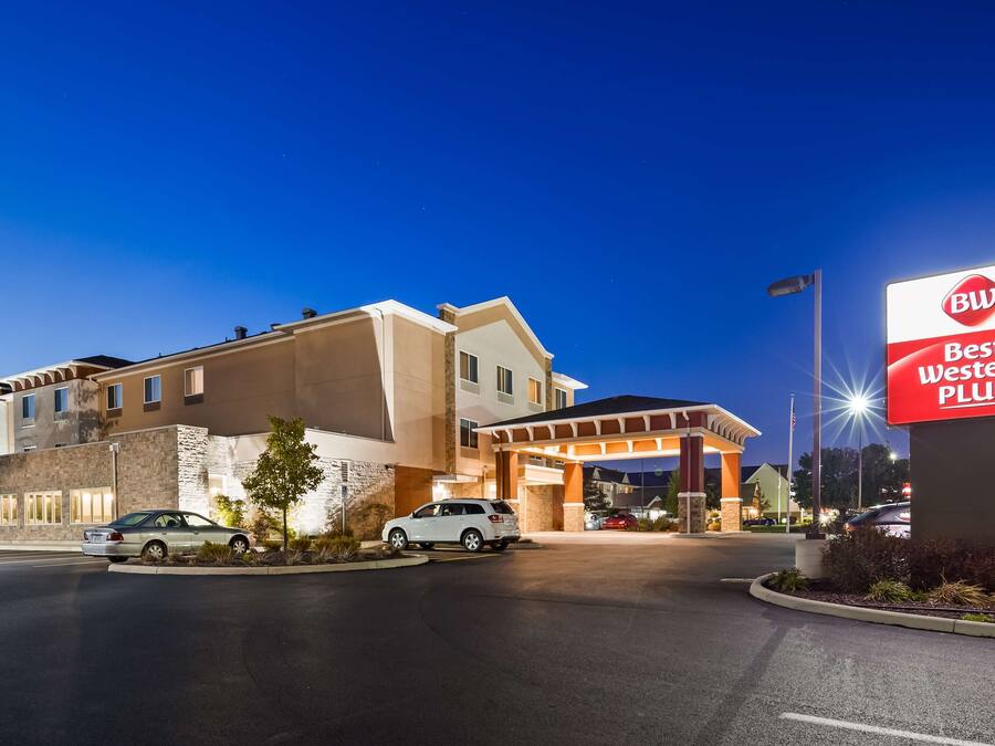 A Best Western Plus hotel with a modern design, featuring a large parking lot and a well-lit entrance.