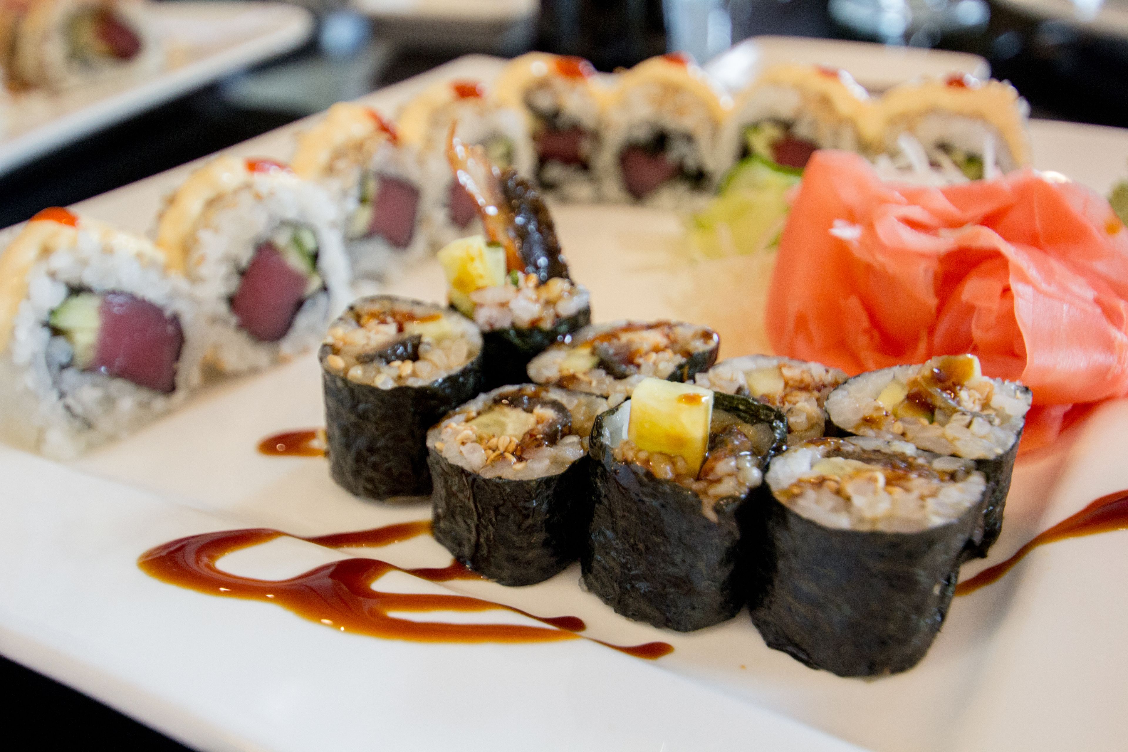 Une assiette de sushis garnis de différentes façons, accompagnée d'une portion de saumon.
