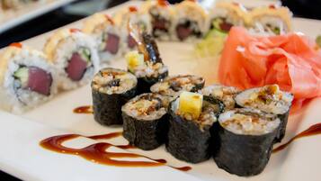Une assiette de sushis garnis de différentes façons, accompagnée d'une portion de saumon.