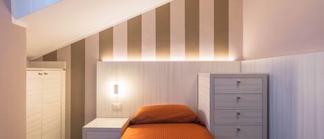 Ein Schlafzimmer mit Bett, Nachttisch, Kommode und Kleiderschrank.
