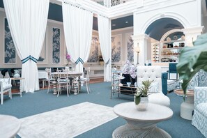 A spacious, elegantly decorated hotel lobby with a high ceiling, ornate ceiling details, and a central seating area with a round table and chairs. - Parc Royale Suites Hotel (Cuenca)