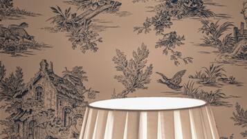 A room with a patterned wallpaper, a lamp, and a window.
