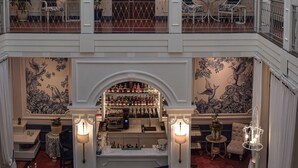 A multi-level hotel lobby with a central atrium, a bar area, and seating arrangements. - Parc Royale Suites Hotel (Cuenca)