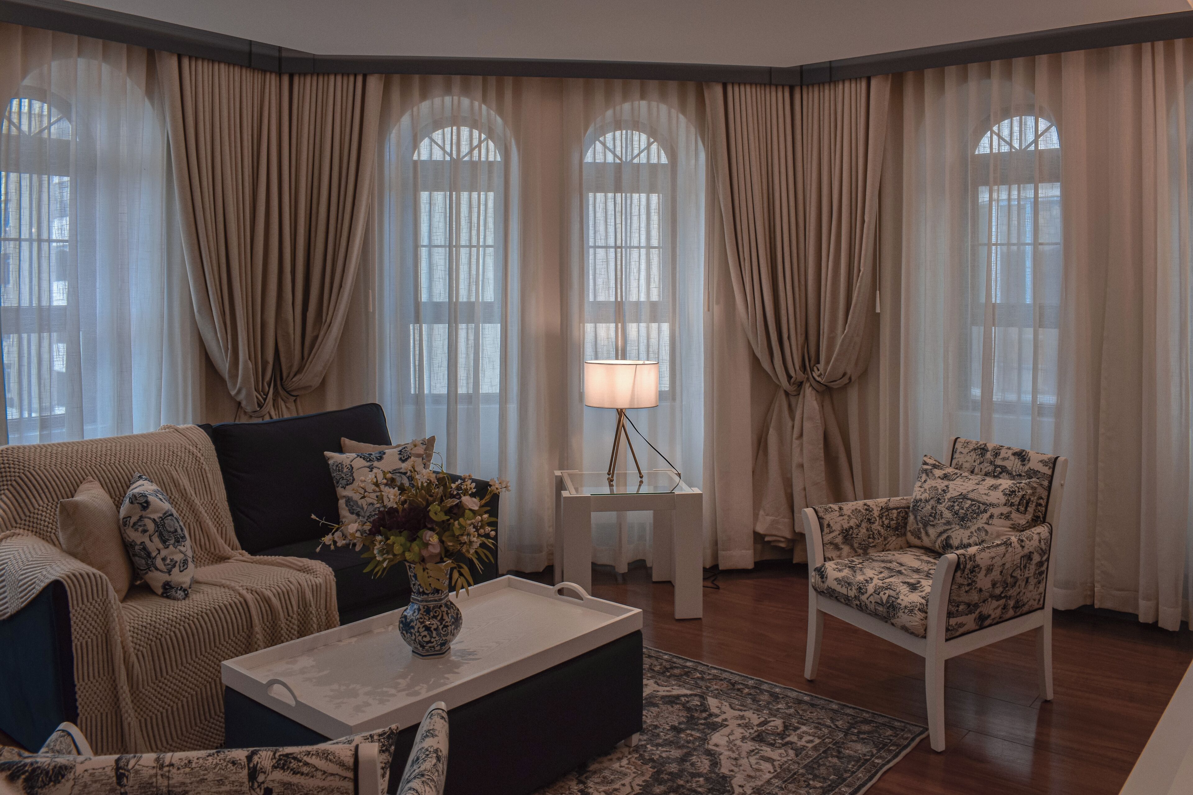 Una sala de estar con sofá, sillón, mesa de centro y lámpara.